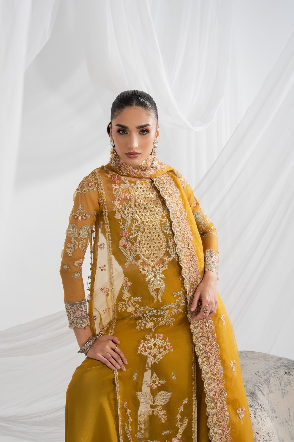 Embroidered organza wedding dress featuring detailed embroidery across the front panels, back, and sleeves, with matching borders and an embroidered organza dupatta, paired with a plain raw silk inner and pants