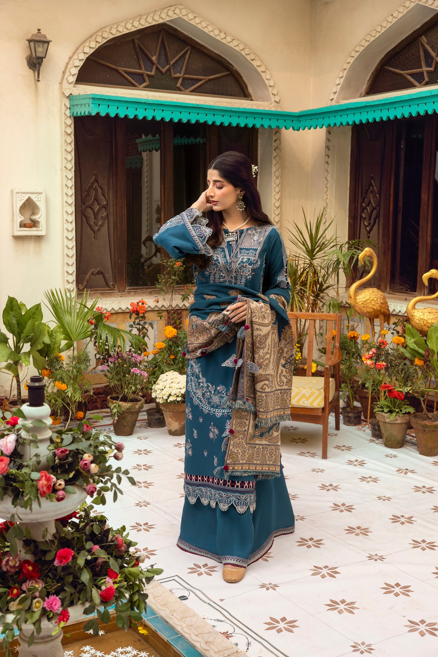 Winter-ready three-piece incorporating intricate embroidery, an organza neckline, and a handwoven Kashmiri shawl.